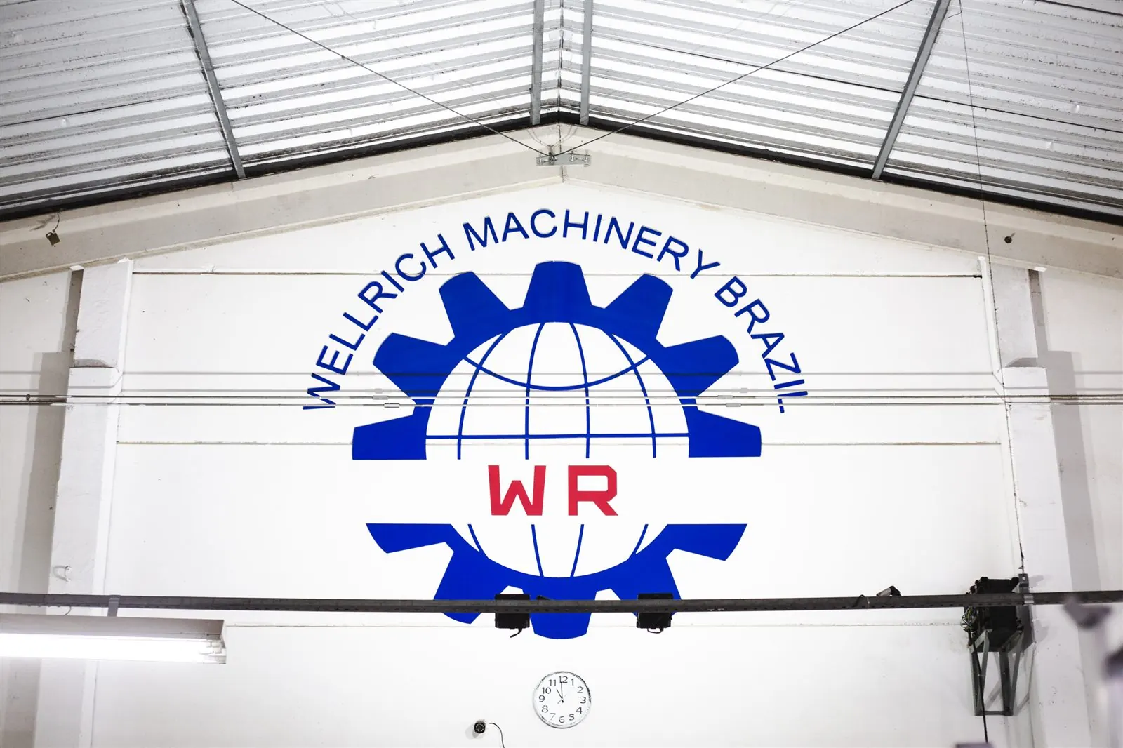 Logo Wellrich Machinery Brazil na parede do galpão do showroom